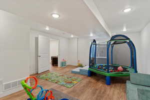 Recreation room featuring wood-type flooring and a textured ceiling