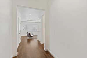 Corridor featuring a tray ceiling and dark hardwood / wood-style flooring