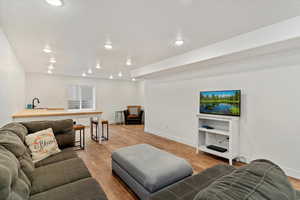 Living room with light hardwood / wood-style floors and sink