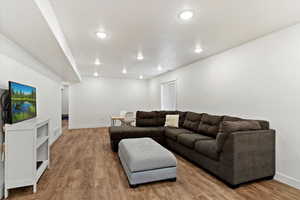 Living room with built in shelves and light hardwood / wood-style flooring