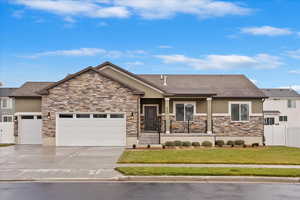 Craftsman-style house featuring a porch, a garage, and a front yard