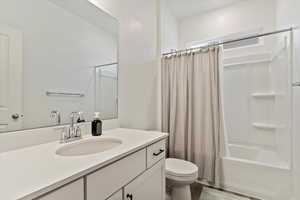 Full bathroom with vanity, toilet, and shower / bath combo with shower curtain