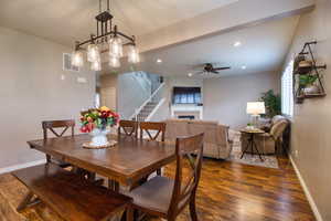 Dining space featuring ceiling fan, a fireplace, and dark hardwood / wood-style floors