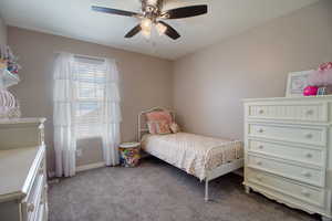 Bedroom with ceiling fan and light colored carpet