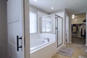 Bathroom with shower with separate bathtub, a textured ceiling, and tile patterned floors