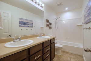 Full bathroom featuring toilet, vanity, and tub / shower combination