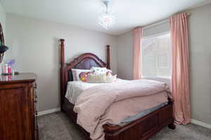 Bedroom featuring carpet flooring and a notable chandelier