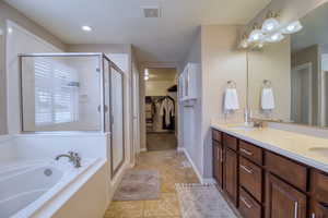 Bathroom featuring tile patterned flooring, shower with separate bathtub, a textured ceiling, and vanity