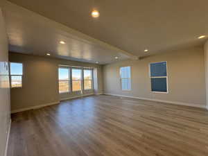 Spare room featuring wood-type flooring, a textured ceiling, and a wealth of natural light