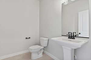 Bathroom with tile patterned floors, toilet, and sink