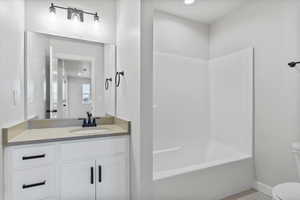 Full bathroom featuring vanity, shower / washtub combination, and toilet