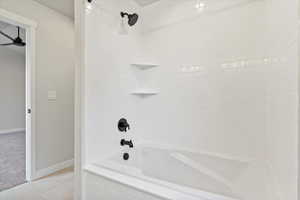 Bathroom with tile patterned flooring, ceiling fan, and tiled shower / bath