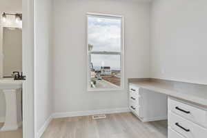 Office space featuring sink and light wood-type flooring