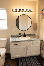 Bathroom featuring hardwood / wood-style floors, vanity, and toilet