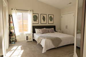 Carpeted bedroom featuring a closet and lofted ceiling