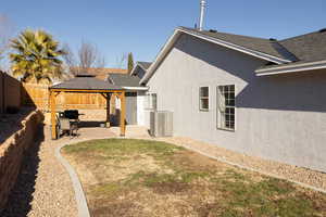 Rear view of house featuring a gazebo, cooling unit, and a patio area