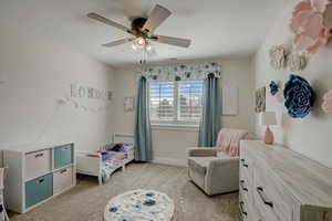 Carpeted bedroom featuring ceiling fan