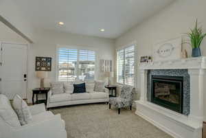 Carpeted living room with a tiled fireplace