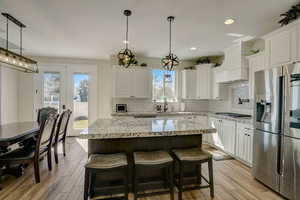 Kitchen with white cabinets, a center island, and stainless steel appliances