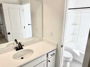 Full bathroom featuring tile patterned floors, vanity, toilet, and shower / washtub combination