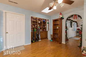 Interior space featuring ceiling fan, light wood-type flooring, and a skylight