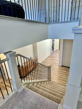 Stairway with a high ceiling and hardwood / wood-style flooring