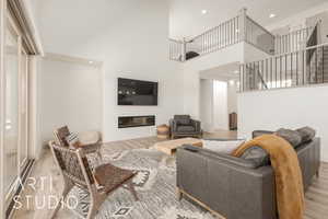 Living room featuring a high ceiling and light hardwood / wood-style flooring