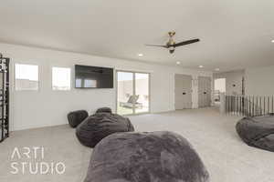 Carpeted family room featuring ceiling fan