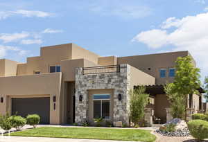 Pueblo-style home featuring a garage