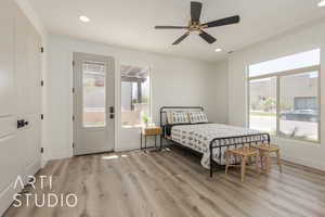 Guest Bedroom #2 with ceiling fan and light hardwood / wood-style flooring, separate entrance