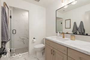 Bathroom with vanity, toilet, and a shower with shower door