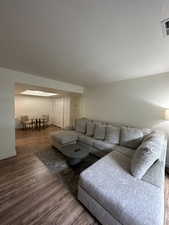 Living room with a skylight and hardwood / wood-style flooring