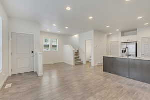 Unfurnished living room featuring light wood-type flooring and sink