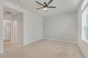 Spare room featuring ceiling fan and light colored carpet