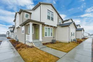 View of front of home with a front lawn and central air condition unit