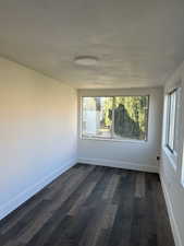 Unfurnished room featuring dark hardwood / wood-style floors