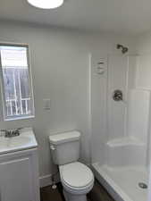 Bathroom featuring toilet, vanity, and walk in shower