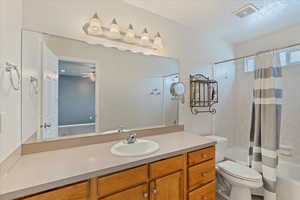 Full bathroom featuring ceiling fan, vanity, shower / tub combo, and toilet