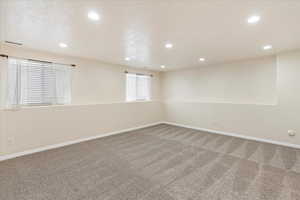 Empty room featuring carpet flooring and a textured ceiling