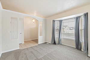 Unfurnished room with light carpet and a textured ceiling