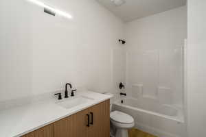 Full bathroom with vanity, shower / bath combination, and toilet