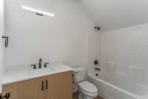 Ensuite bathroom featuring bathtub / shower combination, vanity, and toilet