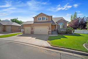 View of front of house featuring a garage and a front lawn