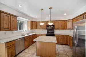 Kitchen featuring a center island, sink, backsplash, decorative light fixtures, and black appliances