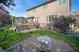 Rear view of house featuring a pergola and a yard