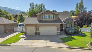 Front of property with a mountain view, a garage, and a front yard