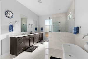 Bathroom featuring vanity and separate shower and tub