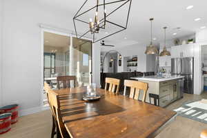 Dining room featuring ceiling fan with notable chandelier, light hardwood / wood-style floors