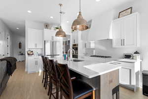 Kitchen featuring breakfast bar, modern lighting