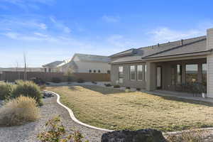 Rear view of house featuring a lawn and a patio